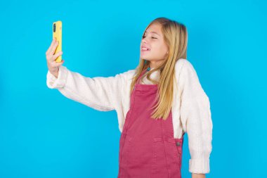 Mutlu, genç bir kızın izole edilmiş fotoğrafı, cep telefonuyla selfie çekiyor. İnsanlar, teknoloji ve eğlence kavramı