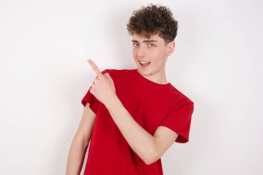 Beyaz arka plandaki yakışıklı genç adam sana doğru bakıyor ve gülümsüyor. Şuraya bak.!