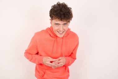 Beyaz arka planda gülümseyen yakışıklı genç adam. Arkadaş canlısı ve mutlu bir şekilde cep telefonu tutuyor. Aynada selfie çekiyor..