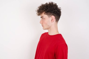 Beyaz arka planda gülümseyen, gülümseyen genç bir adamın yan görüntüsü. 