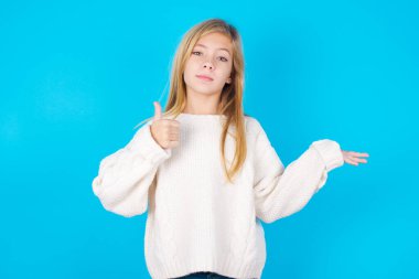 Neşeli, güzel bir genç kız baş parmağını gösterip diğer elini işaret ediyor. Bunu tavsiye ederim..