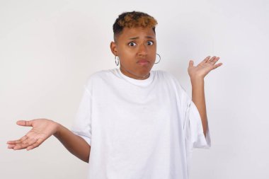 Güzel bir kadın ifadeden şüphe eder, şaşırır ve şaşırır, belirsiz bir gelecek omuzlarını silker, gri duvara karşı durur..