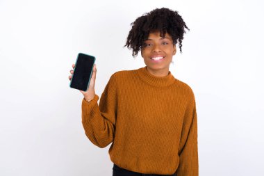 Gülümseyen genç kadın boş telefon ekranı gösteriyor. Reklam ve iletişim konsepti.