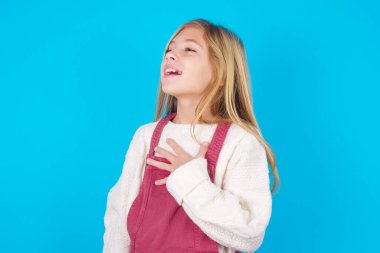 Neşeli güzel kız olumlu duygularını ifade eder. Komik bir şey anımsar. Elini göğsüne koyar ve mutlu bir şekilde kıkırdar..