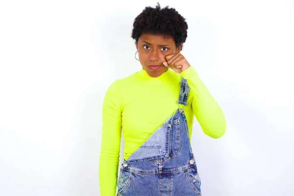 Разочарованная Юная Афроамериканка Короткими Волосами Джинсе Целом Прислоняется Белой Стене — стоковое фото