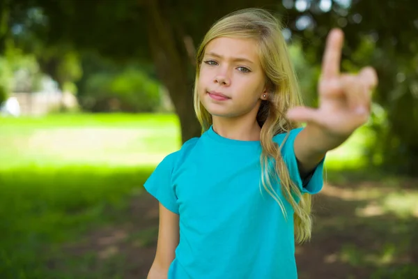 年轻漂亮的女孩站在公园的背景图上 手指手画脚 — 图库照片