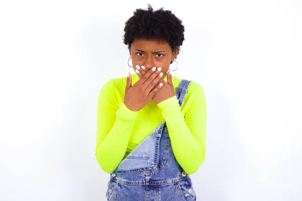 年轻的非洲裔美国女人 头发短 全身都是斜纹棉布 双手沾满了白墙 以避免在看到或听到不好的声音后尖叫 — 图库照片