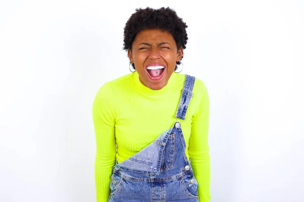 Stresująca Młoda Afroamerykanka Krótkimi Włosami Nosząca Dżinsy Białej Ścianie Krzyczy — Zdjęcie stockowe