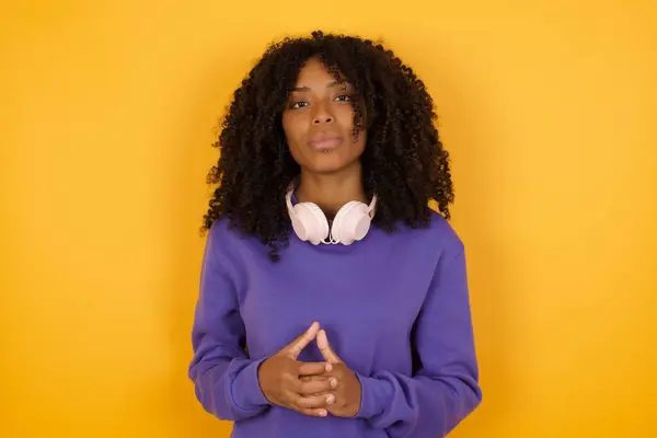Retrato Joven Mujer Afroamericana Expresiva Con Auriculares Sobre Fondo Amarillo Imagen de archivo