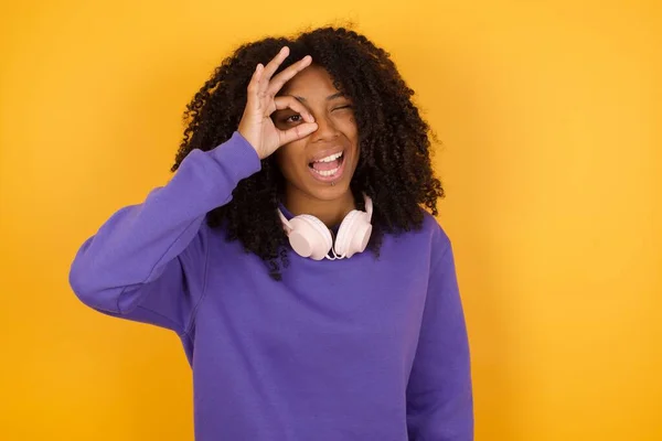 Retrato Joven Mujer Afroamericana Expresiva Con Auriculares Sobre Fondo Amarillo Imágenes de stock libres de derechos