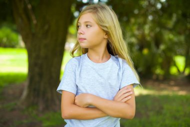 Düşünceli, düşünceli, güzel bir kız kollarını kavuşturmuş, düşünceli bir ifadeyle ne yapacağını düşünüyor.