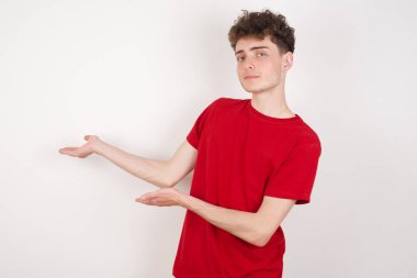 Beyaz arka plandaki yakışıklı genç adam gülümseyerek elleri açık içeri girmeye davet ediyor. Hoş geldin işareti.