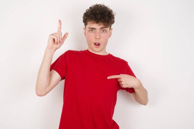 Beyaz arka plandaki yakışıklı genç adam der ki: Vay be, ne kadar heyecan verici, şaşırtıcı bir ifade, bir şey ifade ediyor. Bir eli göğsünde ve diğer eliyle işaret ediyor..