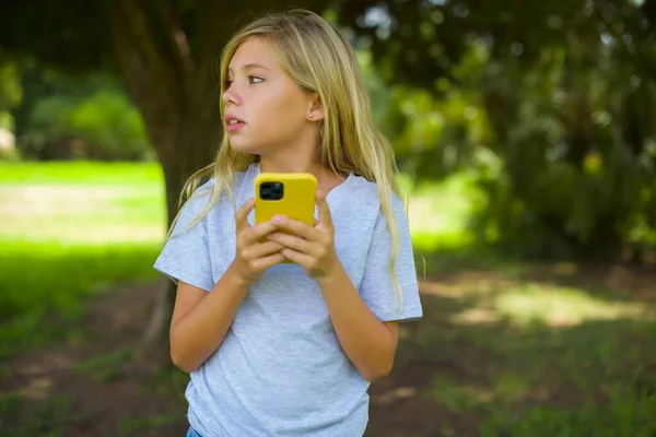Très Ennuyé Jolie Fille Tenant Smartphone Dans Parc — Photo
