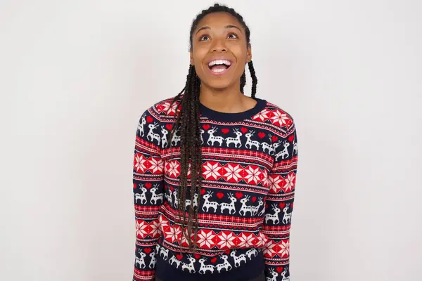 Mujer Afroamericana Sorprendida Vistiendo Suéter Navidad Contra Pared Blanca Encoge —  Fotos de Stock