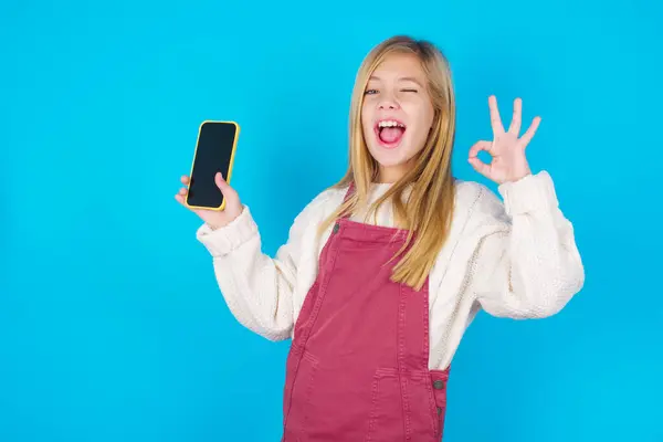 Opgewonden Mooie Tiener Meisje Toont Smartphone Leeg Scherm Knipperend Oog — Stockfoto