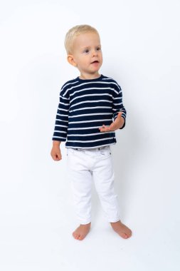 Beyaz arka planda çizgili balıkçı yaka giyen güzel sarışın çocuğun stüdyo portresi.