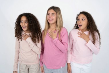 Neşeli üç genç kız olumlu duygularını ifade eder. Komik bir şey anımsar. Elini göğsüne koyar ve mutlu bir şekilde kıkırdar..