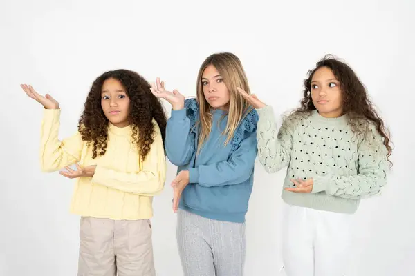 3人のティーンエイジャーの女の子が 両手を脇に置いて 奇妙なものを見せて こう言いました これが何なのか分からない 広告コンセプト — ストック写真