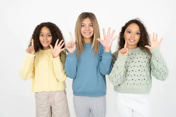 三个少女带着六号手指出现和指点 同时带着自信和快乐的笑容 — 图库照片