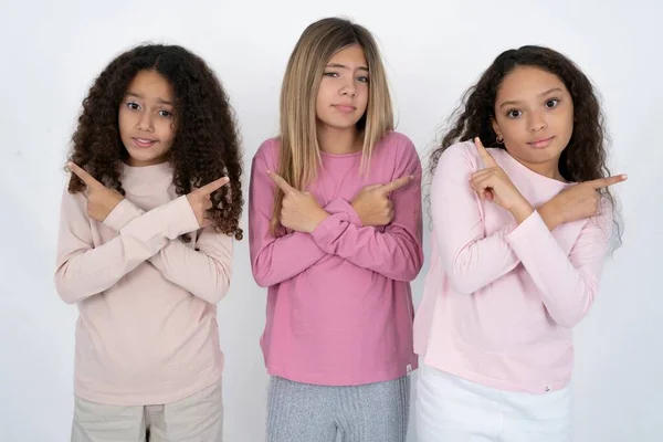 Tři Dospívající Dívky Zkříží Ruce Ukazuje Různé Strany Váhá Mezi — Stock fotografie