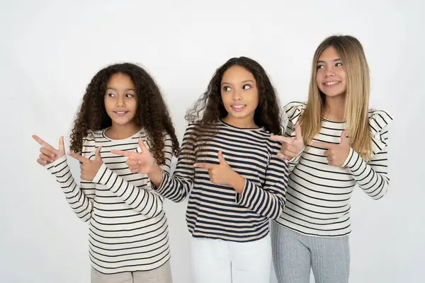 Optimista Tres Chicas Adolescentes Señala Con Ambas Manos Mirando Espacio —  Fotos de Stock