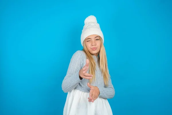 Fröhlich Schönes Mädchen Mit Weißem Strickmütze Und Blauem Pullover Zwinkert — Stockfoto