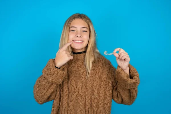 Blonde Kid Girl Wearing Brown Knitted Sweater Blue Background Holding — Stock Photo, Image