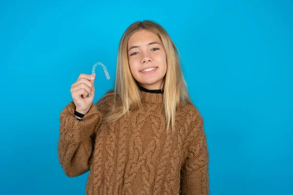 Blonde Kid Girl Wearing Brown Knitted Sweater Blue Background Holding — Stock Photo, Image