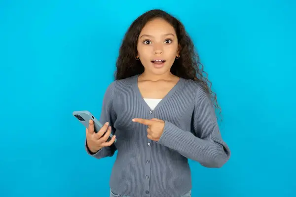 Nastolatka Dziewczyna Noszenie Szary Sweter Gospodarstwa Ręce Pokazując Nowe Komórki — Zdjęcie stockowe