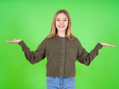 Neşeli, neşeli, iyimser, beyaz, yeşil süveter giyen, elinde iki avuç içi fotokopi alanı tutan güzel bir kız.