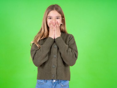 Yeşil kazak giyen güzel beyaz kız neşe içinde kıkırdıyor, ağzını kapatıyor, doğal kahkahaları var, olumlu hikayeler duyuyor ya da komik anekdotlar dinliyor.