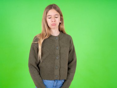 Kasvetli, reddedilmiş, yeşil kazak giyen güzel beyaz kız sorunları ve zorlukları var, alt dudak kıvrımları var, umutsuzluk içinde gözlerini kapatıyor, depresyonda.