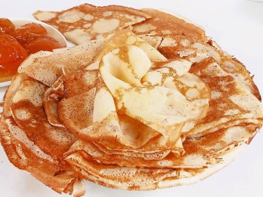 Kayısı reçelinin yanında, tabakta bir yığın kızarmış krep..