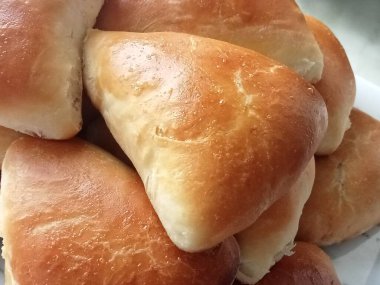 Birkaç altın kahverengi, fırında, üçgen şeklinde turtalar üst üste yığılmış..