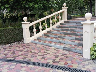 Tırabzanları olan taş merdivenler ve yeşilliklerle çevrili merdiven. Kırmızı-kahverengi ve gri tonlarda çok renkli asfalt levhalardan yapılmış, desenli bir yüzey yaratıyor. Adımlar geniş ve naziktir..