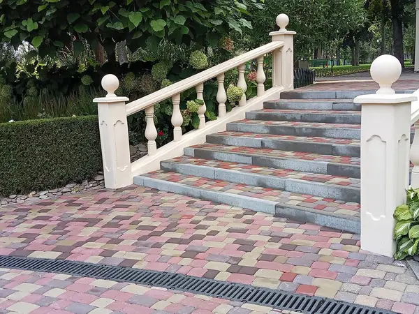 Tırabzanları olan taş merdivenler ve yeşilliklerle çevrili merdiven. Kırmızı-kahverengi ve gri tonlarda çok renkli asfalt levhalardan yapılmış, desenli bir yüzey yaratıyor. Adımlar geniş ve naziktir..