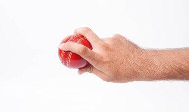 Beyaz arka planda kırmızı test maçında sıkıca tutunan bir erkek oyuncunun yakın plan fotoğrafı.