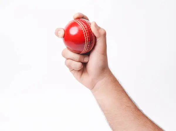 stock image Closeup Photo Of A Male Bowler Firmly Gripping On A Red Test Match Cricket Ball On White Background