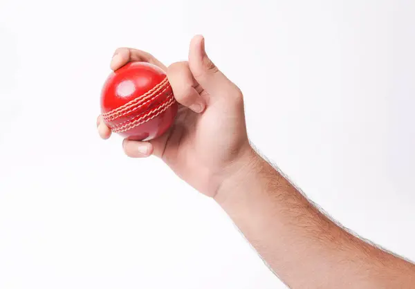 stock image Closeup Photo Of A Male Bowler Firmly Gripping On A Red Test Match Cricket Ball On White Background