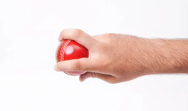 stock image Closeup Photo Of A Male Bowler Firmly Gripping On A Red Test Match Cricket Ball On White Background