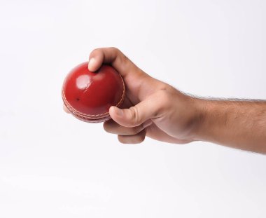 Beyaz arka planda kırmızı test topuna sıkıca sarılan bir erkek oyuncunun yakın plan fotoğrafı.