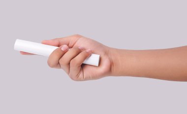 Beyaz arka planda izole edilmiş beyaz bir PVC plastik boru tutan bir erkeğin yakın plan fotoğrafı.