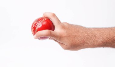 Closeup Photo Of A Male Bowler Firmly Gripping On A Red Test Match Cricket Ball On White Background clipart