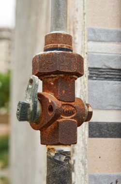 Paslı metal bir valfın yakın plan çekimi. Boru gösterimindeki aşınma ve uzun süre maruz kalmaktan dolayı aşınması.