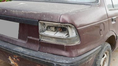 Rear End Of An Aged Dusty Car Missing Tail Light, Rusted Bumper And Faded Paint Showcasing Neglect clipart