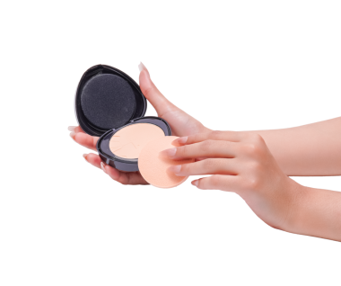 Makyaj uygulaması için kozmetik pudra ve sünger tutan kadın elleri.