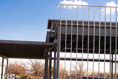 Mavi gökyüzü modern duvarına karşı çok katlı yeni bir ticari binanın çelik iskeleti.