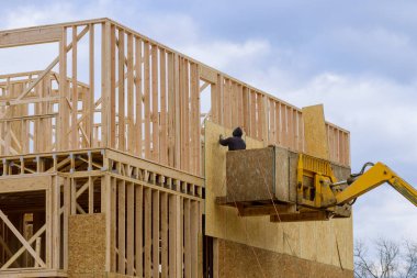 new wooden frame house under construction, outdoor residential home lumber site plywood