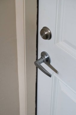 chrome handle with keyhole on white door with panels in frames close-up photo modern style steel